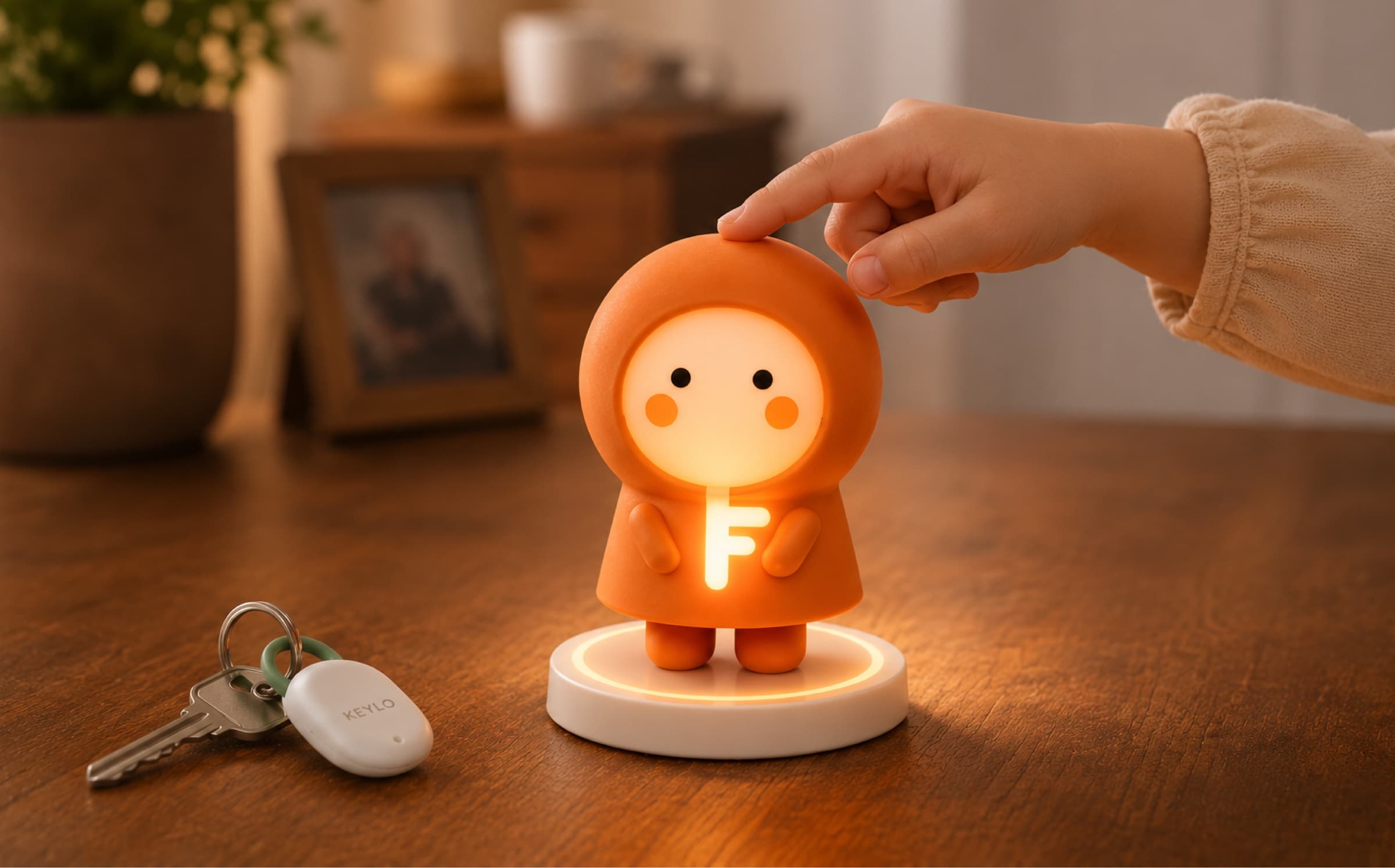 A child touching Keylo on its dock, with a Keylo key fob nearby on the table